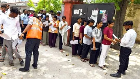 Students waiting outside a NEET UG exam center with their admit cards.